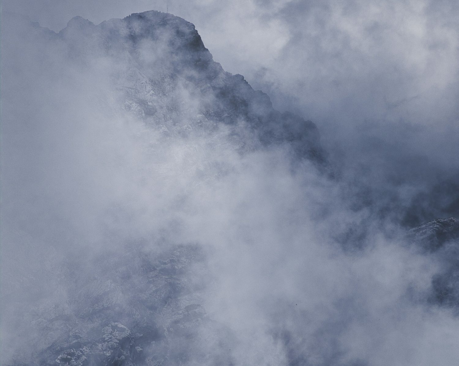 Mountain ridge partially obscured by mist and cloud.